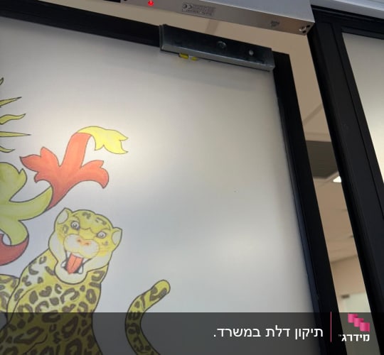 מכשיר אינטרקום מותקן על דלת זכוכית עם עיטור נמר